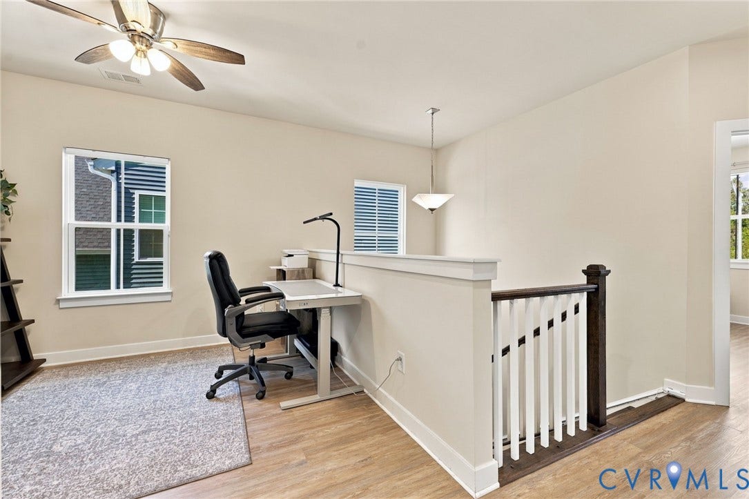 1716 German School Road, Westlake Heights, Richmond, VA 23225 Wood-finish flooring, half-wall partition with a wooden cap, painted wood balusters with a dark wood newel post, multi-light ceiling fan, and pendant lighting