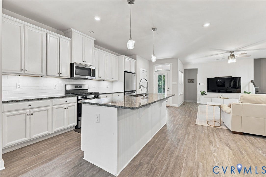 1716 German School Road, Westlake Heights, Richmond, VA 23225 Kitchen featuring white shaker-style cabinetry, stone-surface countertops, a center island with a stainless steel faucet, subway tile backsplash, and wood-finish flooring