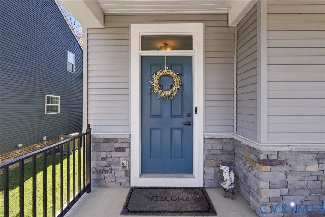 1716 German School Road, Westlake Heights, Richmond, VA 23225 Covered entryway featuring a solid-panel blue door with a transom window, horizontal lap siding, and stone veneer base