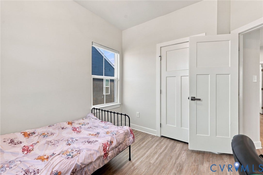 1716 German School Road, Westlake Heights, Richmond, VA 23225 Room featuring wood-finish flooring, a single-hung window, and a three-panel shaker-style door with matte black hardware