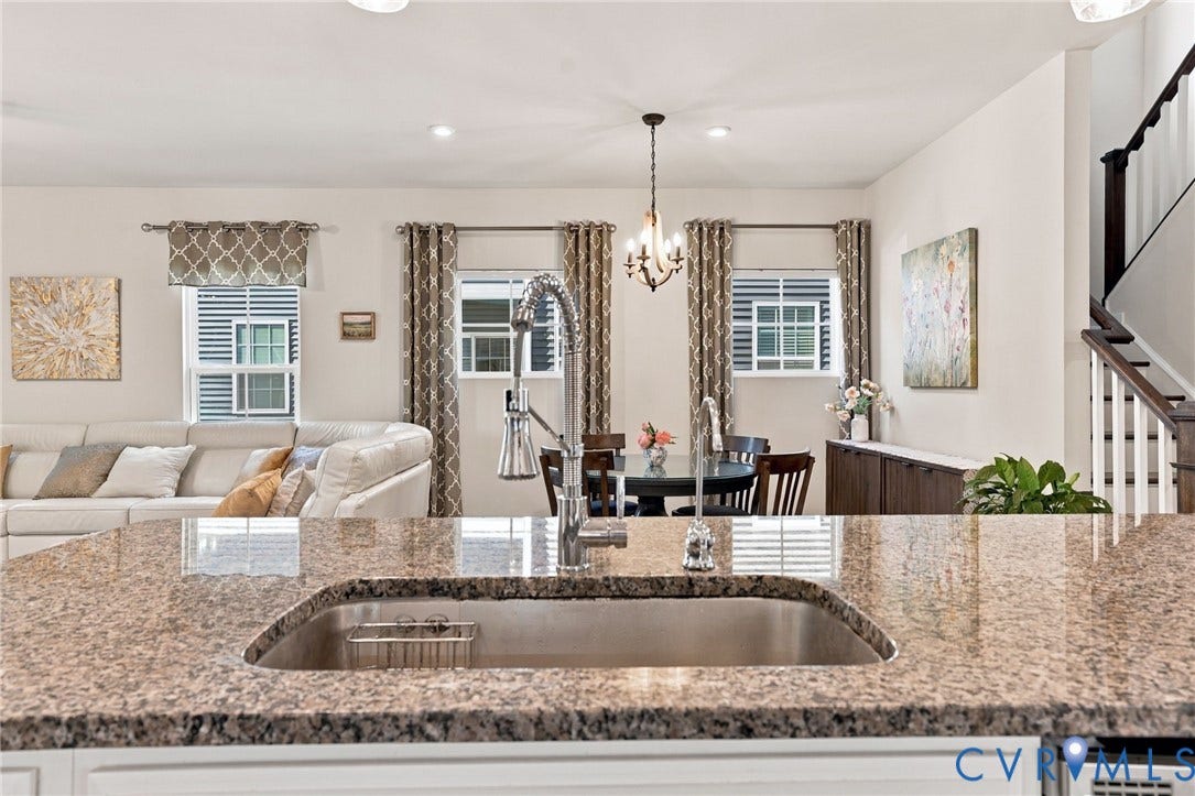 1716 German School Road, Westlake Heights, Richmond, VA 23225 Stone countertop with an undermount sink and high-arc pull-down faucet, featuring a central chandelier, recessed lighting, and a custom built-in cabinetry unit