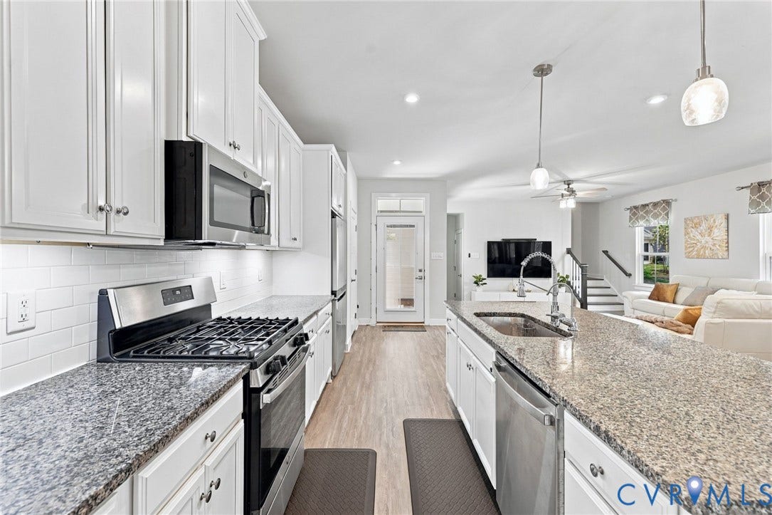 1716 German School Road, Westlake Heights, Richmond, VA 23225 Kitchen featuring white shaker-style cabinetry, stone countertops, a subway tile backsplash, stainless steel appliances, and a central island with an integrated sink