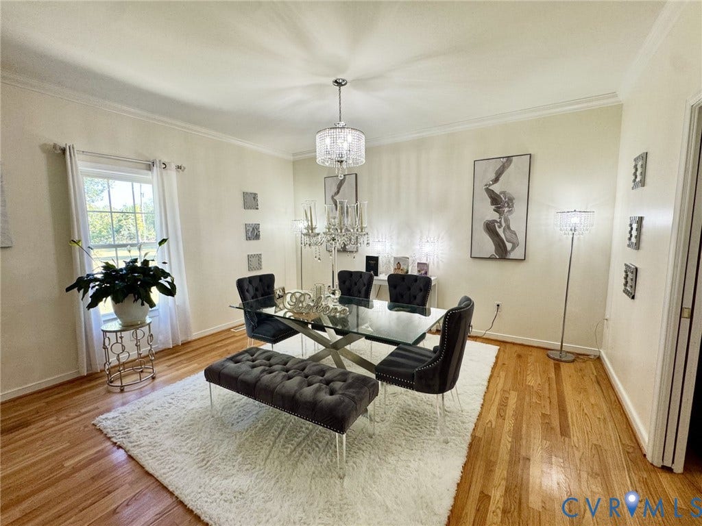 Formal room with crown molding, wood-finish flooring, and a crystal chandelier