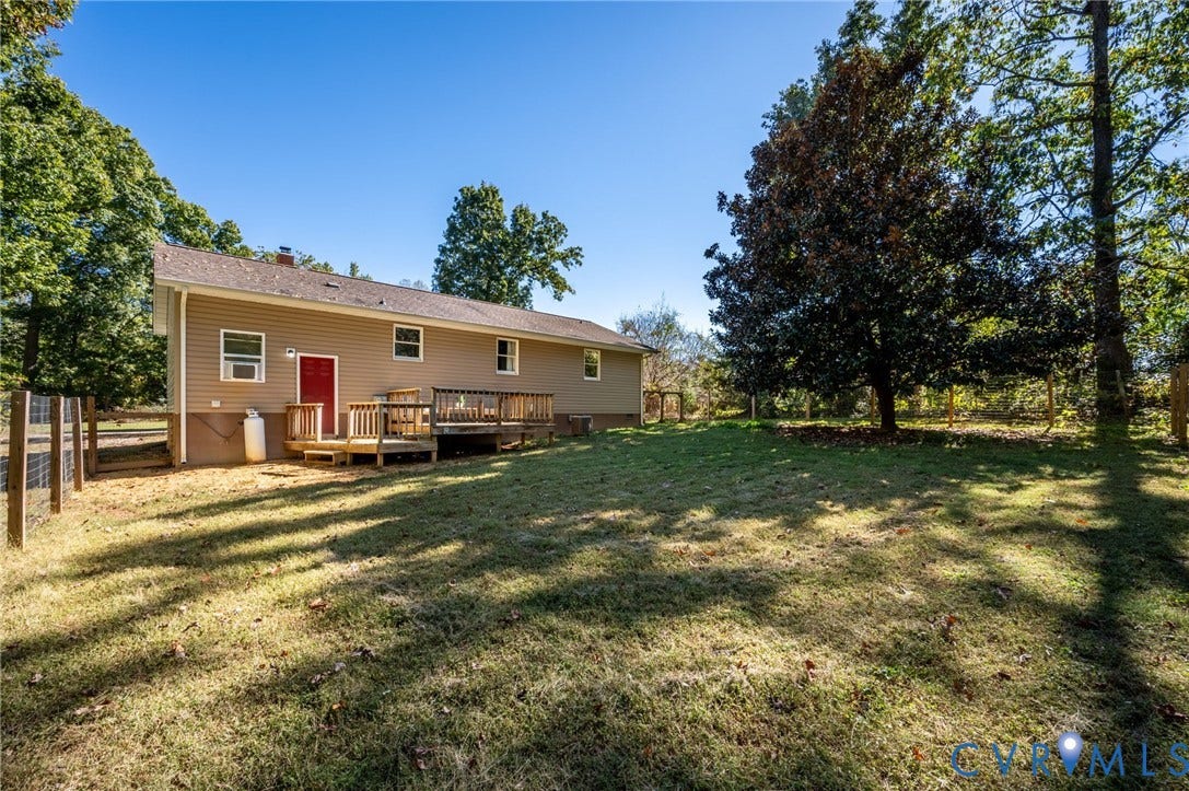 2790 Maidens Road, Powhatan, VA 23139 Exterior featuring vinyl siding, a wood deck, and a fenced-in grassy yard with mature trees