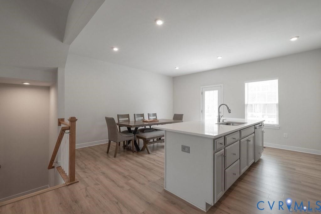 10221 Wenden Way, Hanover, VA 23005 Kitchen featuring a central island with a solid surface countertop, stainless steel undermount sink, recessed lighting, and wood-finish flooring