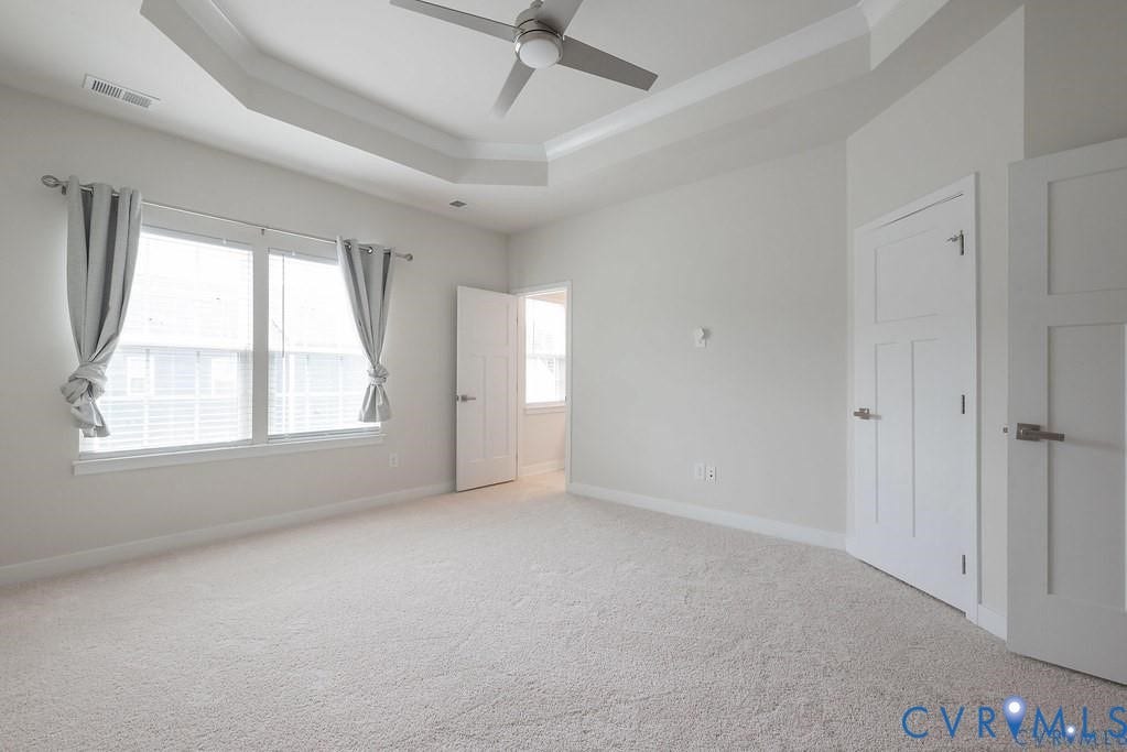 10221 Wenden Way, Hanover, VA 23005 Tray ceiling with a centered ceiling fan, neutral wall paint, carpeting, and multi-panel interior doors