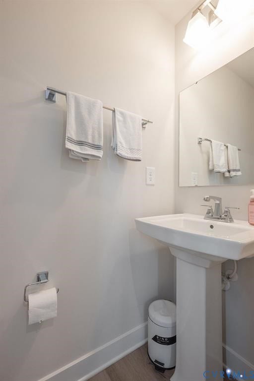 10221 Wenden Way, Hanover, VA 23005 Pedestal sink with a polished chrome faucet, rectangular wall-mounted mirror, brushed nickel towel bar, and wood-finish flooring