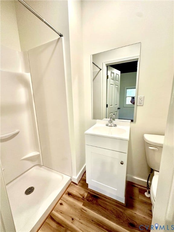 15051 BENT CREEK ROAD, Morven, Amelia, VA 23002 Bathroom featuring a shower stall with a molded surround, white vanity cabinet with an integrated sink, rectangular frameless mirror, and wood-finish flooring