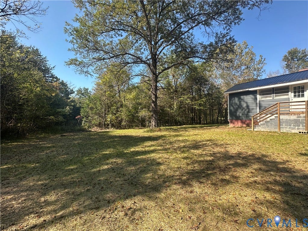 15051 BENT CREEK ROAD, Morven, Amelia, VA 23002 Expansive grounds featuring mature trees, open lawn space, metal roof, and wooden exterior staircase