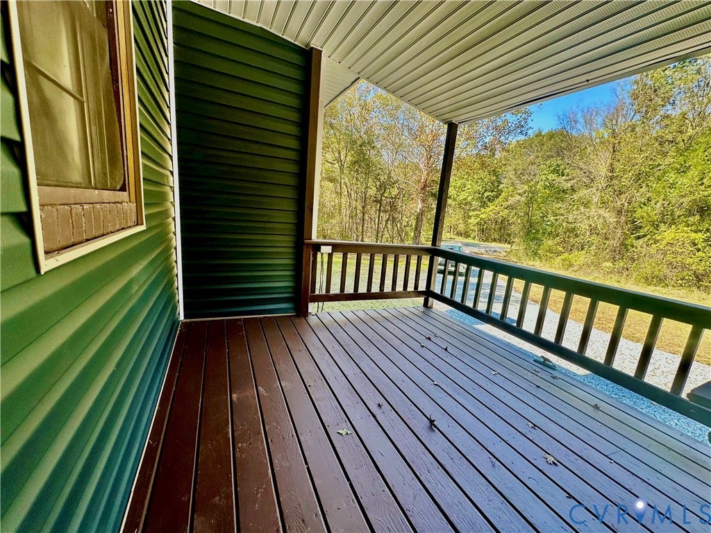 15051 BENT CREEK ROAD, Morven, Amelia, VA 23002 Covered porch featuring dark wood-finish decking, horizontal vinyl siding, and wooden railings