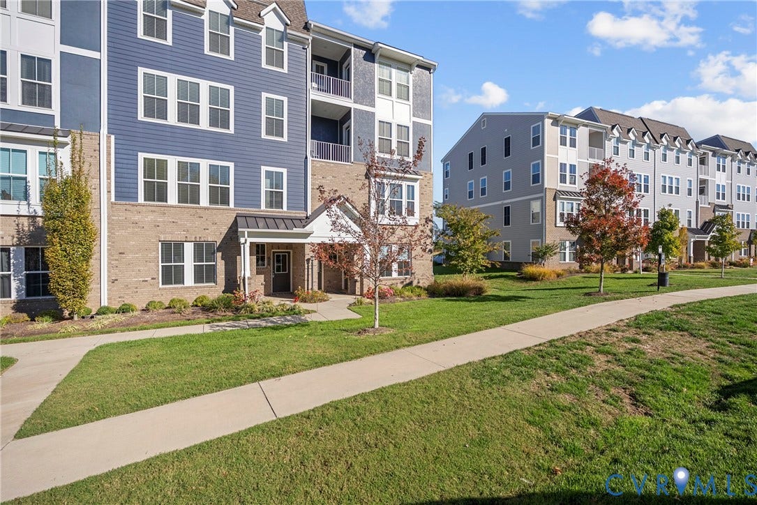 14501 Hancock Towns Drive, Chesterfield, VA 23832 Multi-story building exterior featuring a mix of brick and horizontal siding, private recessed balconies, and paved pedestrian walkways throughout the landscaped grounds