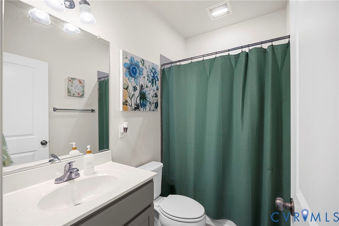14501 Hancock Towns Drive, Chesterfield, VA 23832 Bathroom featuring a vanity with an integrated basin, polished metal faucet, large wall-mounted mirror, overhead three-light fixture, and a combination tub and shower