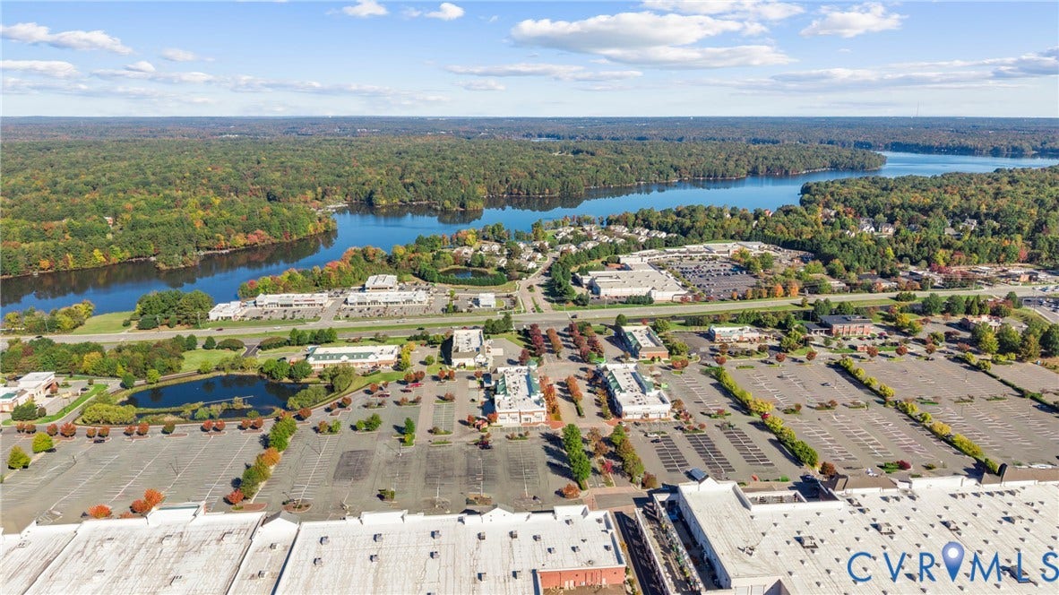 14501 Hancock Towns Drive, Chesterfield, VA 23832 Aerial perspective featuring expansive paved parking surfaces, multiple commercial buildings with flat roofing, and proximity to wooded waterfront areas