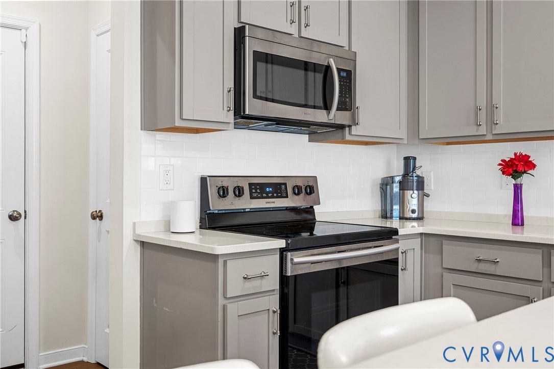 14501 Hancock Towns Drive, Chesterfield, VA 23832 Shaker-style cabinetry with neutral finish, white subway tile backsplash, solid-surface countertops, and stainless steel built-in microwave and range