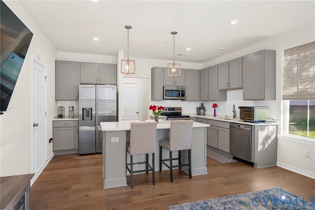 14501 Hancock Towns Drive, Chesterfield, VA 23832 Kitchen featuring grey cabinetry, quartz countertops, a central island with dual pendant lighting, stainless steel appliances, and wood-finish flooring