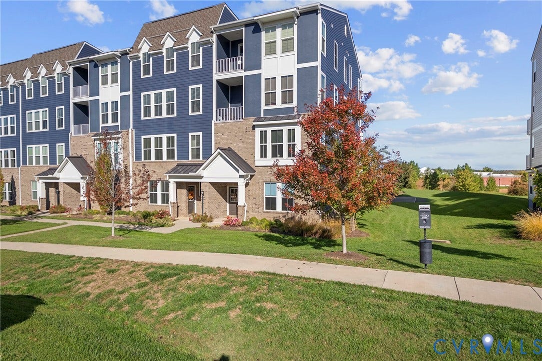 14501 Hancock Towns Drive, Chesterfield, VA 23832 Multi-level exterior featuring dark blue horizontal siding, tan brick masonry, metal-accented gabled roof lines, and private recessed balconies