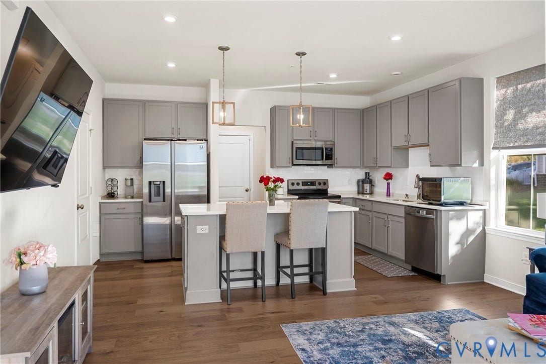 14501 Hancock Towns Drive, Chesterfield, VA 23832 Kitchen featuring light gray cabinetry, a central island with a white countertop, wood-finish flooring, stainless steel appliances, and pendant lighting