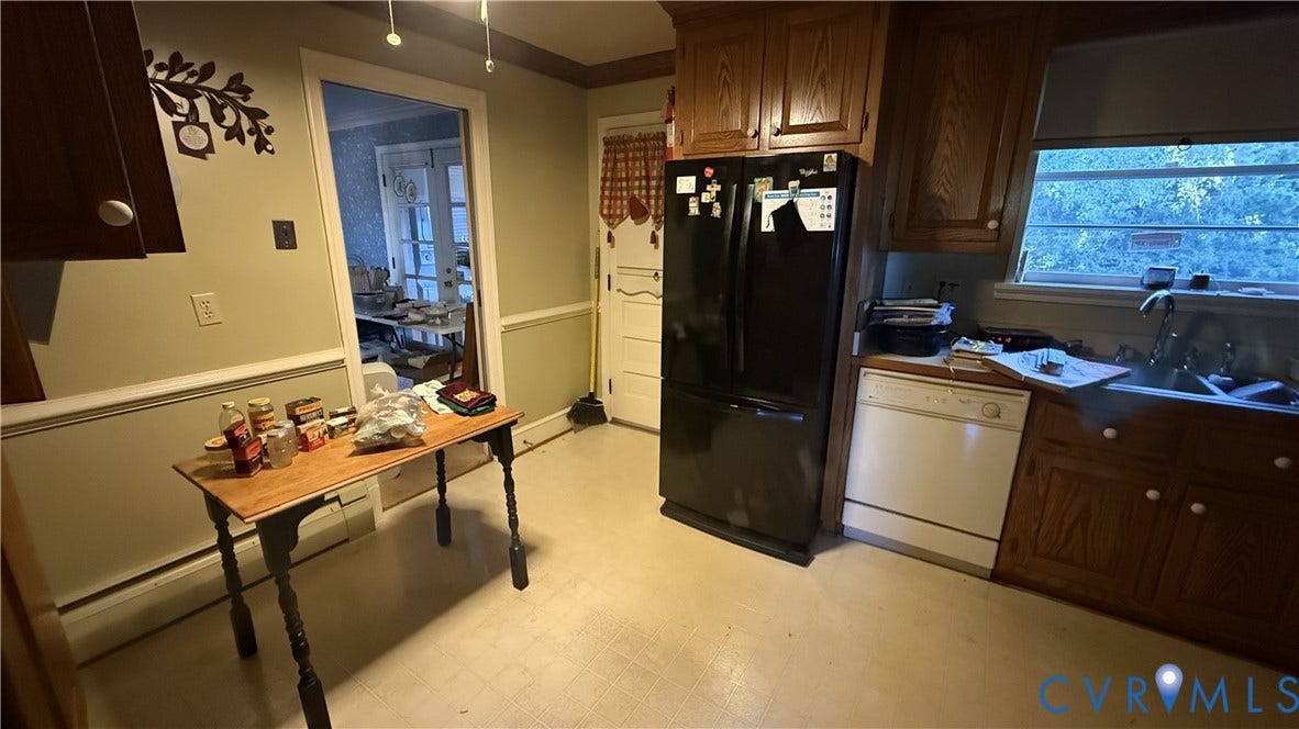 Kitchen featuring wood cabinetry, chair rail molding, and a dual-basin sink with a gooseneck faucet