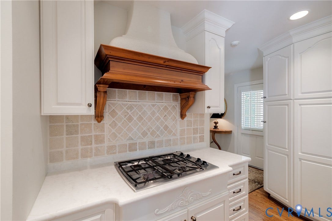 205 Poplar Lane, South Of Cary Street Rd, Richmond, VA 23226 The cooktop area features a stone tile backsplash and lighted wood decorative hood. Passageway leads to the 2nd entrance area and back hallway.