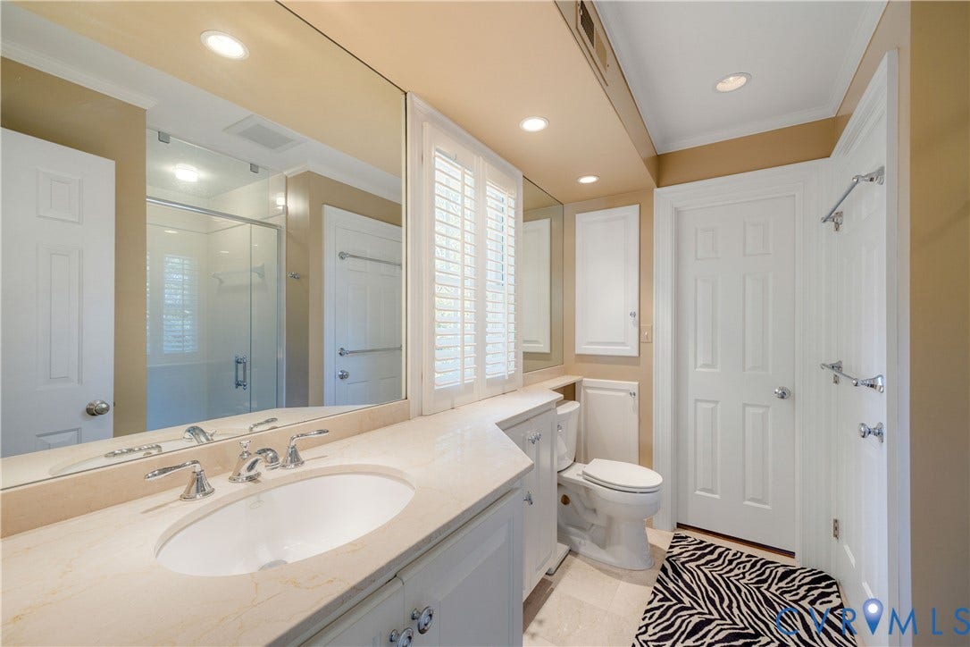 205 Poplar Lane, South Of Cary Street Rd, Richmond, VA 23226 Shared bath between bedrooms two and three features a stone-surface vanity with an integrated oval sink, full-width wall mirror, recessed lighting, white cabinets glass enclosed shower and wall-up access to the third floor. bonus room.