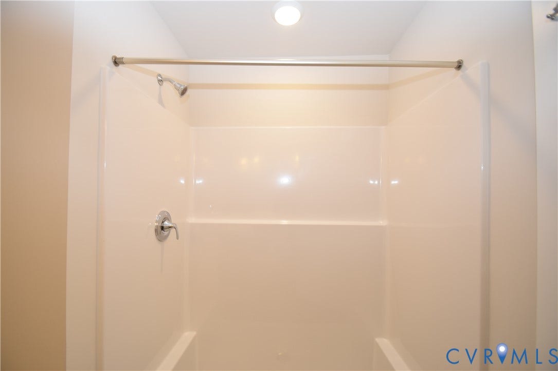 Lot 1 Bannister Town Road, Courtney Farms, Louisa, VA 23093 Bathtub and shower combination featuring a seamless acrylic surround, single-handle faucet, integrated showerhead, and a metal shower curtain rod
