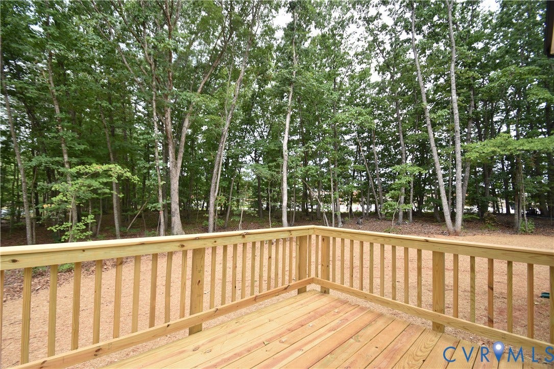 Lot 1 Bannister Town Road, Courtney Farms, Louisa, VA 23093 Wood deck featuring a natural finish and vertical balustrade railing, overlooking a wooded lot with mature trees
