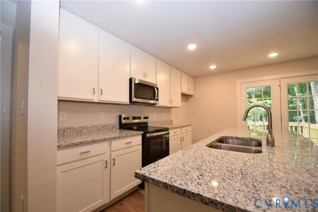 Lot 1 Bannister Town Road, Courtney Farms, Louisa, VA 23093 Kitchen featuring white shaker-style cabinetry, stone-finish countertops, stainless steel appliances, a center island with an undermount dual-basin sink, and recessed lighting