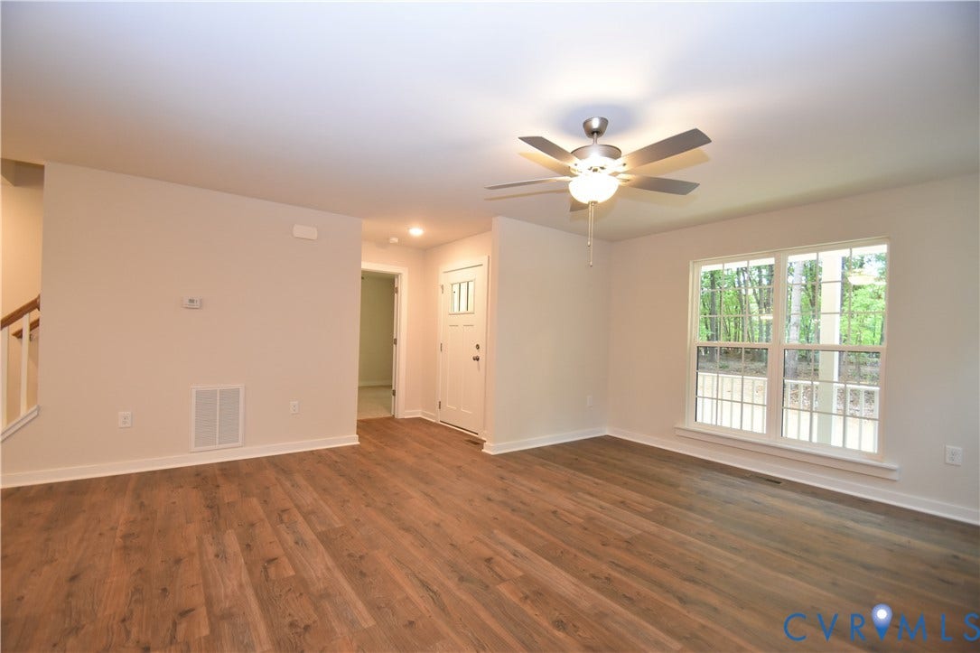 Lot 1 Bannister Town Road, Courtney Farms, Louisa, VA 23093 Living area featuring wood-finish flooring, a multi-blade ceiling fan with integrated lighting, and a large grid-pattern window