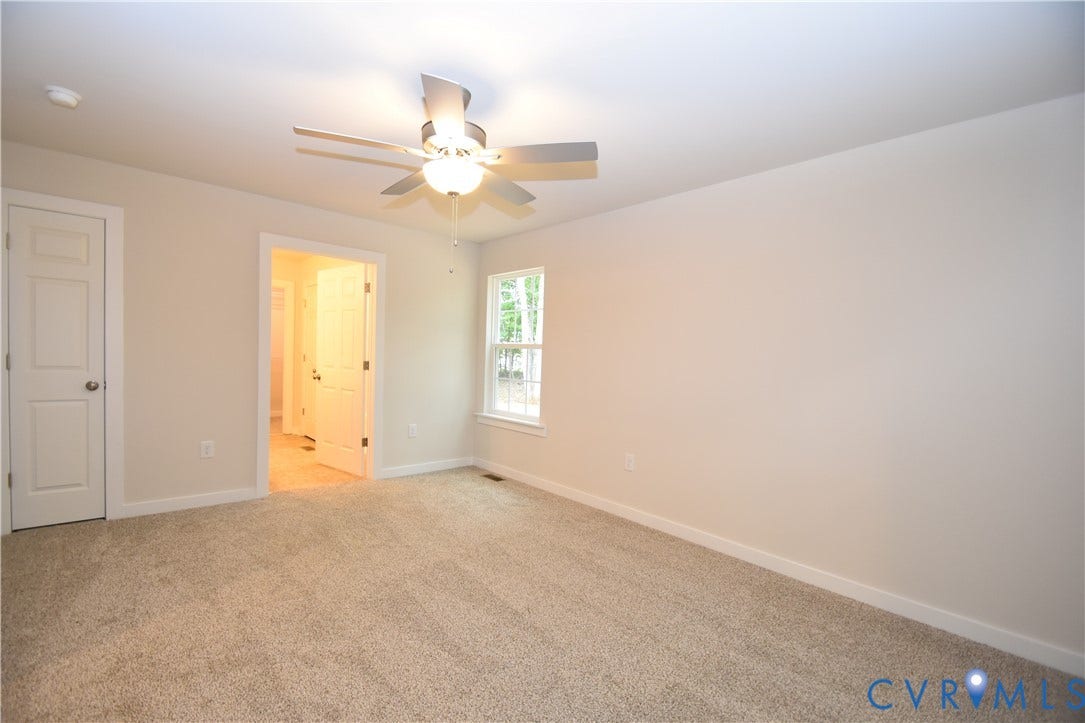 Lot 1 Bannister Town Road, Courtney Farms, Louisa, VA 23093 Neutral-toned room featuring neutral carpeting, a ceiling fan with integrated lighting, two six-panel doors, and a single-pane window