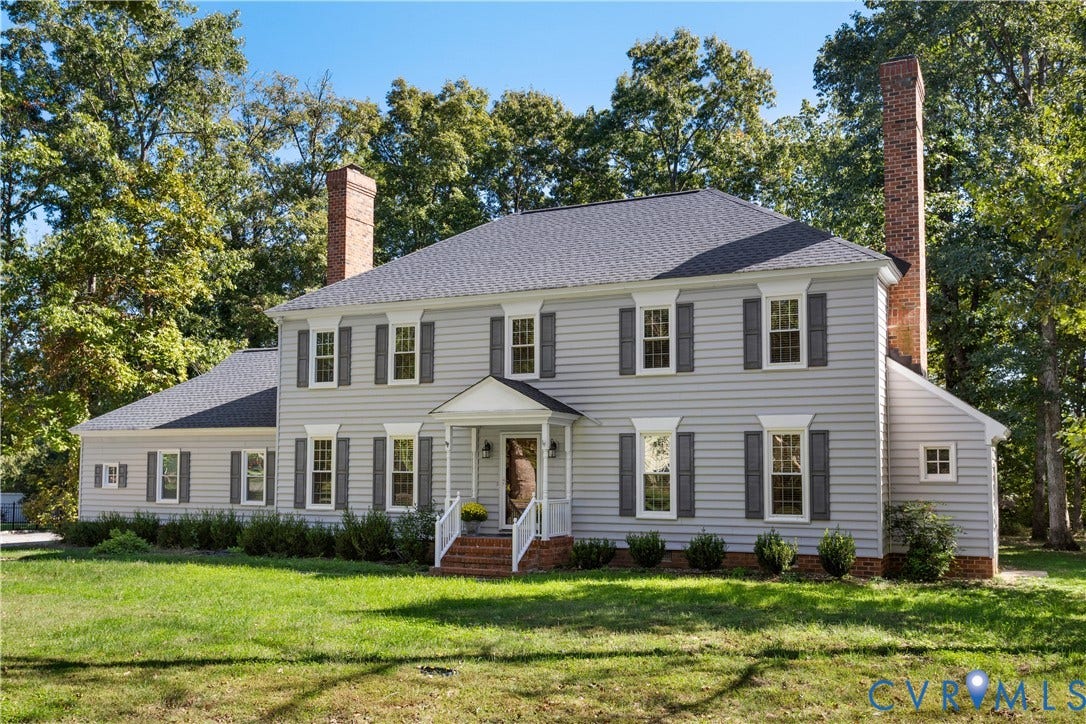 327 Huddersfield Drive, Chesterfield, VA 23236 Two-story exterior featuring horizontal siding, dual brick chimneys, a covered front portico, and shutter-framed windows