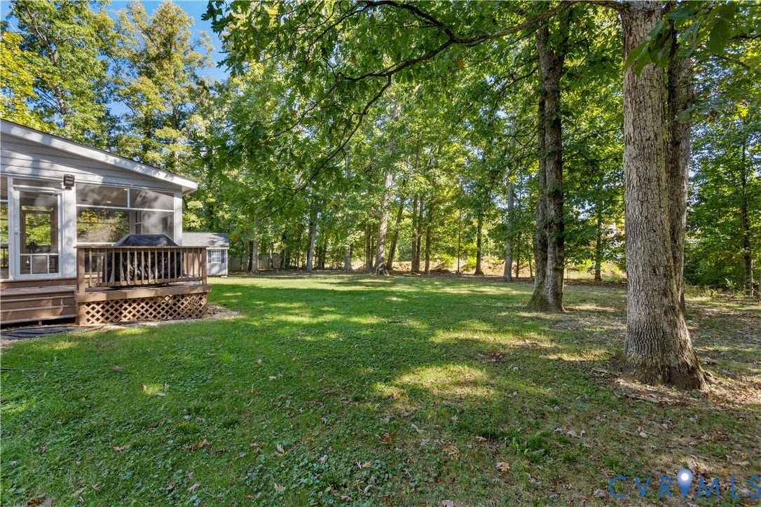 327 Huddersfield Drive, Chesterfield, VA 23236 Spacious backyard featuring a wood deck with lattice skirting and mature trees