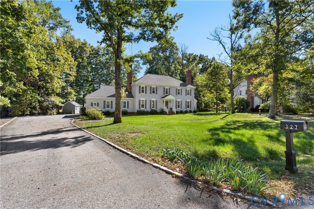 327 Huddersfield Drive, Chesterfield, VA 23236 Two-story Colonial exterior featuring gray siding, symmetrically placed windows with shutters, twin brick chimneys, and an attached gravel driveway