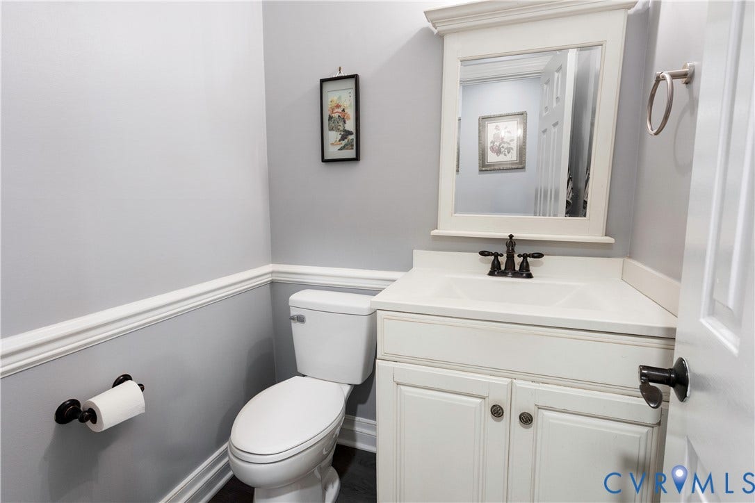 327 Huddersfield Drive, Chesterfield, VA 23236 Powder room featuring a white vanity with an integrated basin, a framed wall mirror, a widespread faucet in a dark finish, and chair rail molding