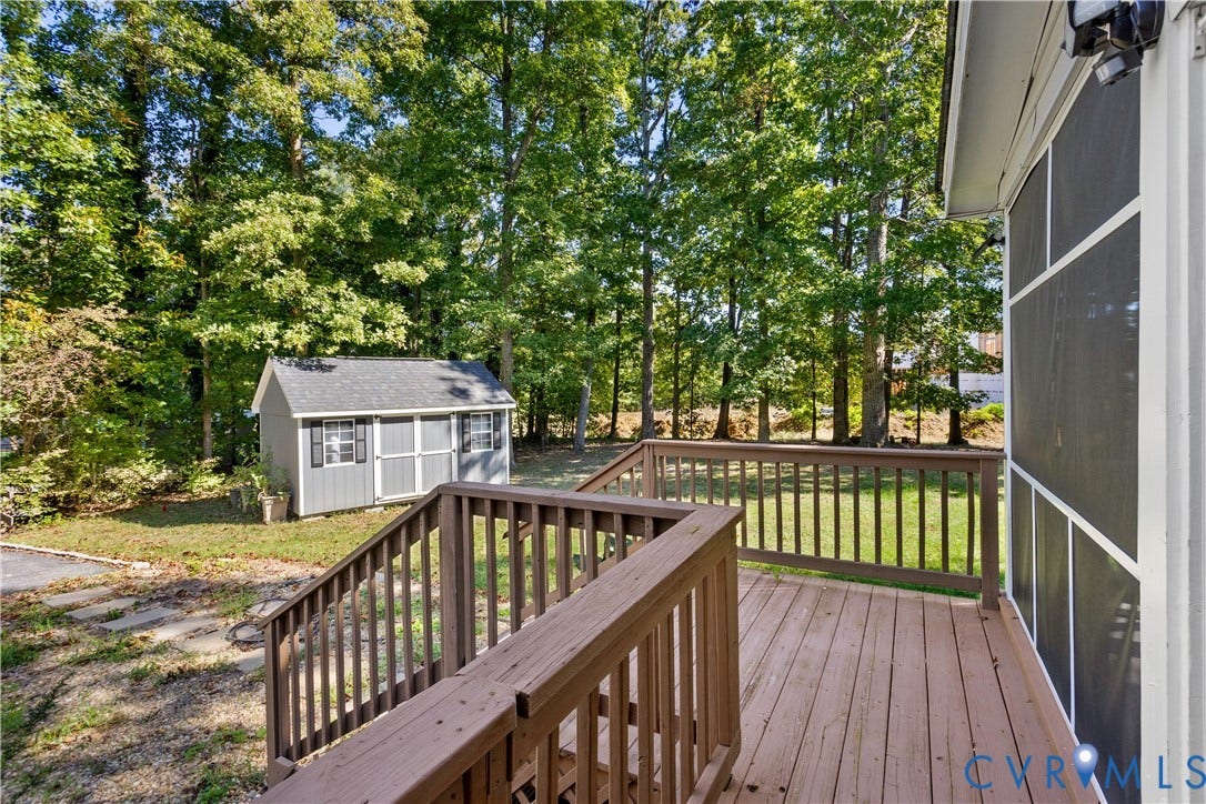 327 Huddersfield Drive, Chesterfield, VA 23236 Elevated wooden deck with balustrades, screened enclosure, detached storage shed, and mature tree-lined perimeter
