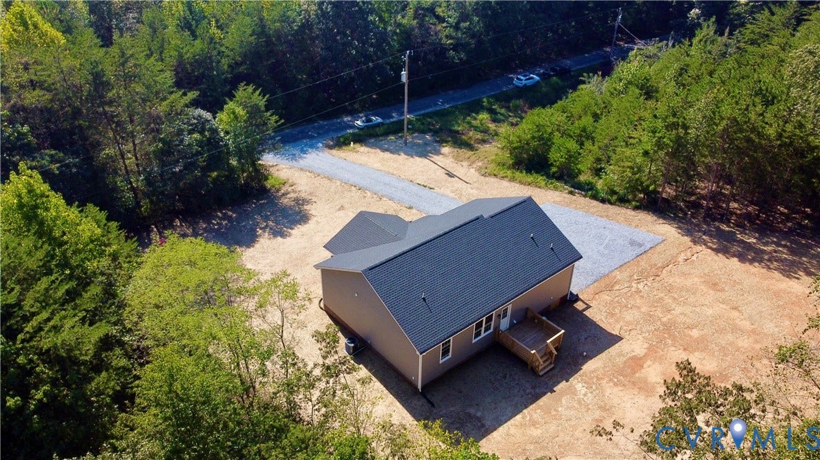 5951 Pot Rock Lane, Pot Rock Ln, Jetersville, VA 23083 Gabled roof structure with dark shingling, elevated wooden deck, and gravel driveway situated on a wooded lot