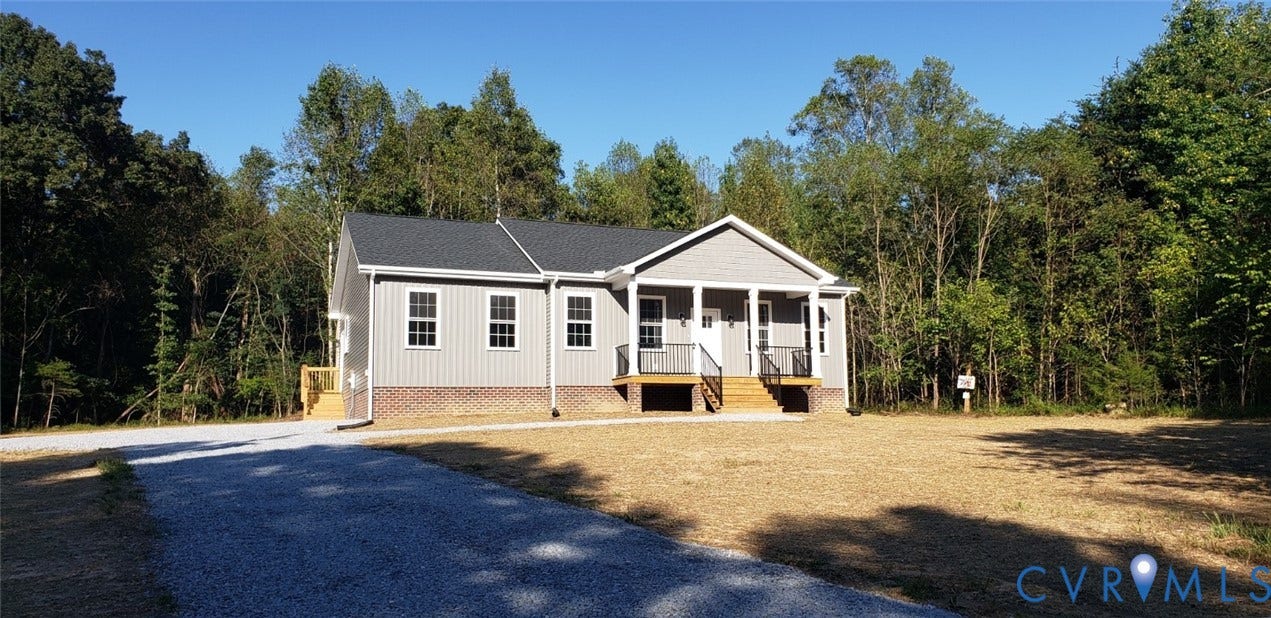 5951 Pot Rock Lane, Pot Rock Ln, Jetersville, VA 23083 Single-story residence featuring vertical siding, a brick foundation, a covered front porch with metal railing, and a gravel driveway