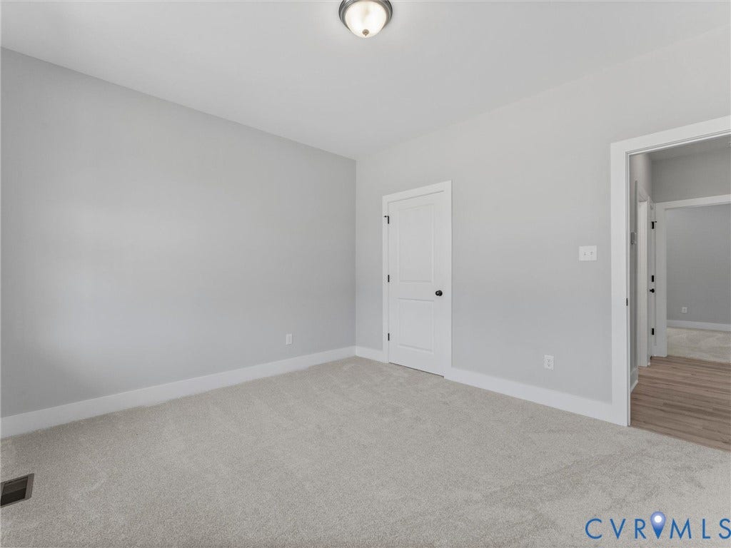 5951 Pot Rock Lane, Pot Rock Ln, Jetersville, VA 23083 Neutral-toned interior room featuring wall-to-wall carpeting, a two-panel interior door, and a central flush-mount ceiling light fixture