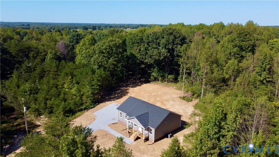 5951 Pot Rock Lane, Pot Rock Ln, Jetersville, VA 23083 Aerial perspective of a detached residential structure featuring a gable roof, concrete driveway, and covered front entry, set on a sprawling parcel surrounded by mature woodland
