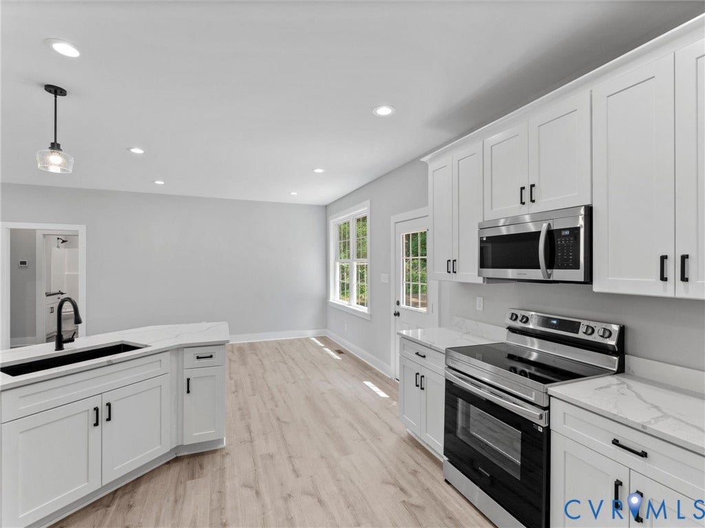 5951 Pot Rock Lane, Pot Rock Ln, Jetersville, VA 23083 Kitchen featuring white shaker-style cabinetry, stainless steel appliances, quartz countertops, a dual-basin sink with a matte black faucet, and wood-finish flooring