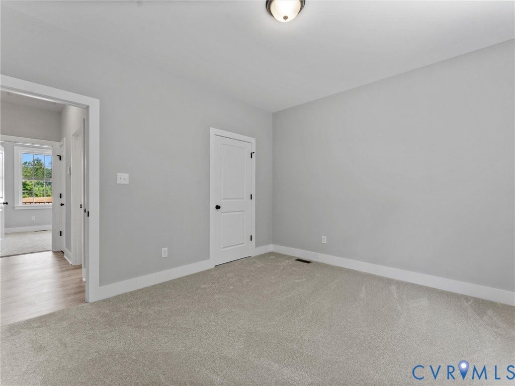 5951 Pot Rock Lane, Pot Rock Ln, Jetersville, VA 23083 Neutral-toned interior room featuring wall-to-wall carpeting, two-panel interior doors with matte black hardware, and a flush-mount ceiling light fixture