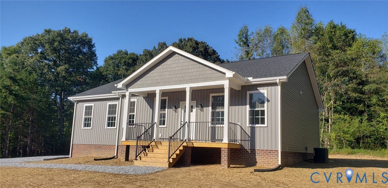 5951 Pot Rock Lane, Pot Rock Ln, Jetersville, VA 23083 Single-story exterior featuring gray vertical siding, a brick foundation, a covered front porch with wood decking, and black metal railings