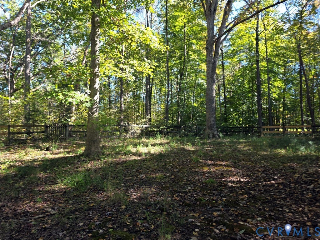 3350 North Road, Sandy Hook, VA 23153 Wooded backyard area featuring a post-and-rail perimeter fence and mature trees