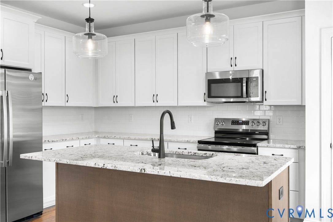 652 Overby Bend Road, Highland Grove, Richmond, VA 23222 Kitchen featuring white shaker-style cabinetry with dark hardware, stainless steel appliances, and a central island with a wood-finish base and light-toned countertop
