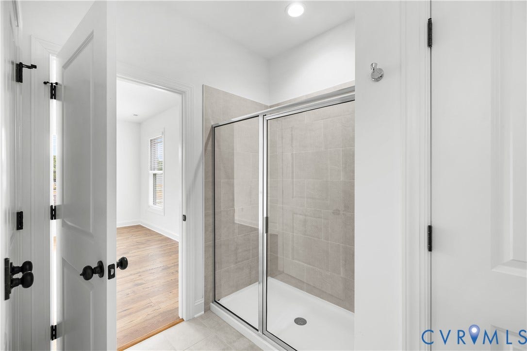652 Overby Bend Road, Highland Grove, Richmond, VA 23222 Shower enclosure with framed glass door, light grey tile surround, and white shower pan