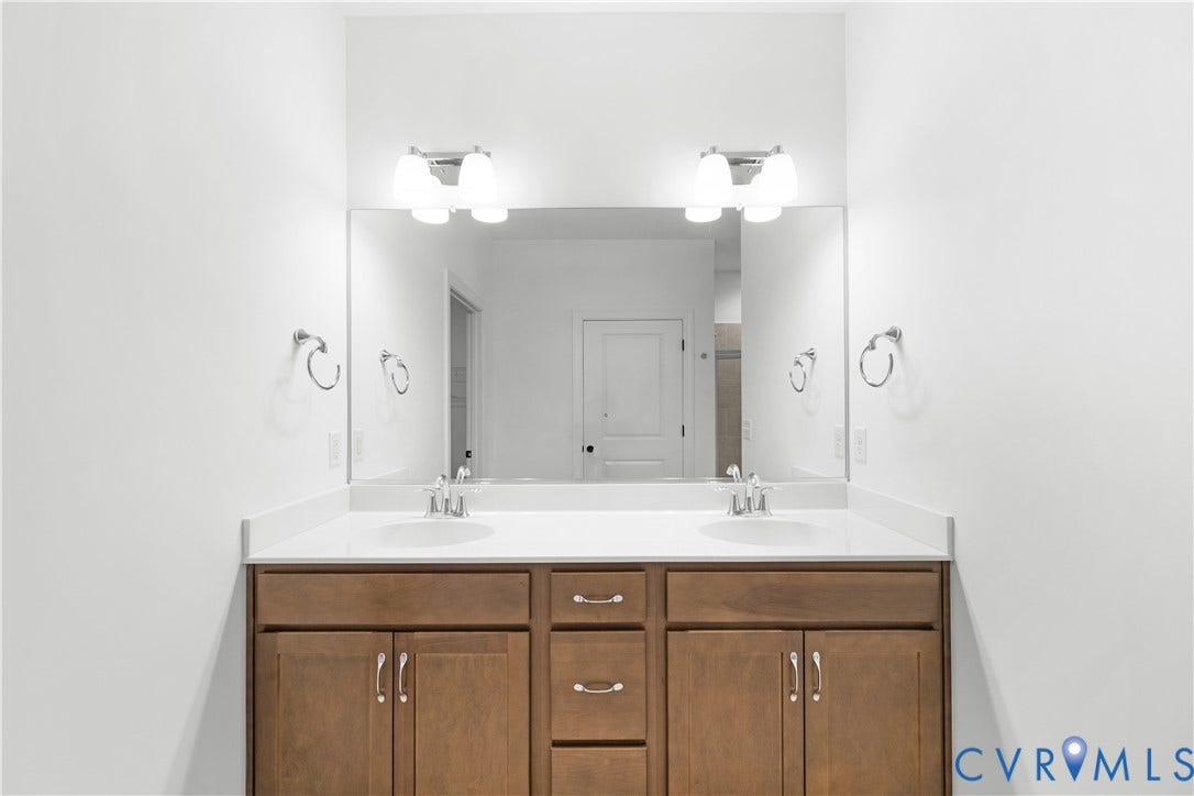 652 Overby Bend Road, Highland Grove, Richmond, VA 23222 Double vanity with wood-finish cabinetry, white countertop, and dual undermount sinks