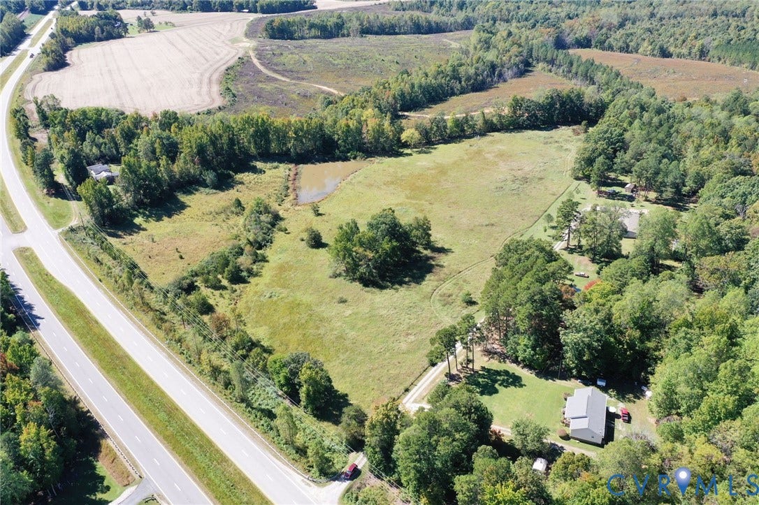 00 Patrick Henry HWY, Detached, Burkeville, VA 23922 Aerial perspective of expansive acreage featuring open pasture land, a natural pond, and mature tree clusters