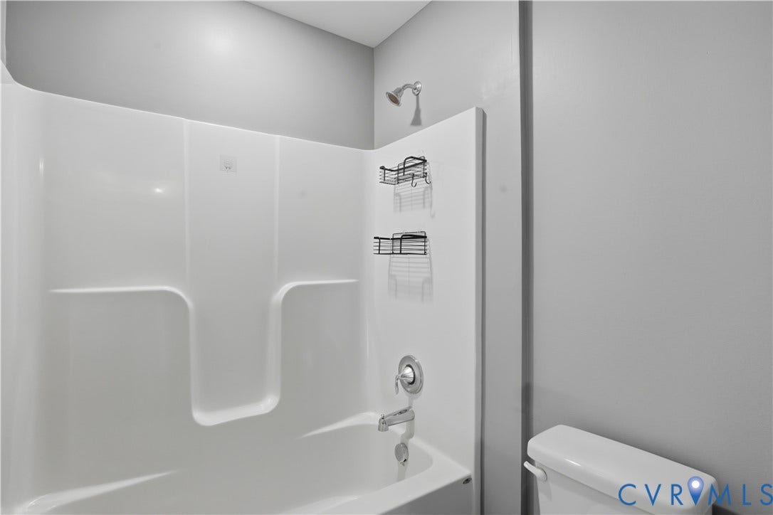 11936 Helmway Court, Chester, VA 23839 Jack and Jill Upstairs bathroom. Bathtub and shower combination featuring a seamless white surround, chrome-finished wall-mounted shower head, and matching metal faucet hardware