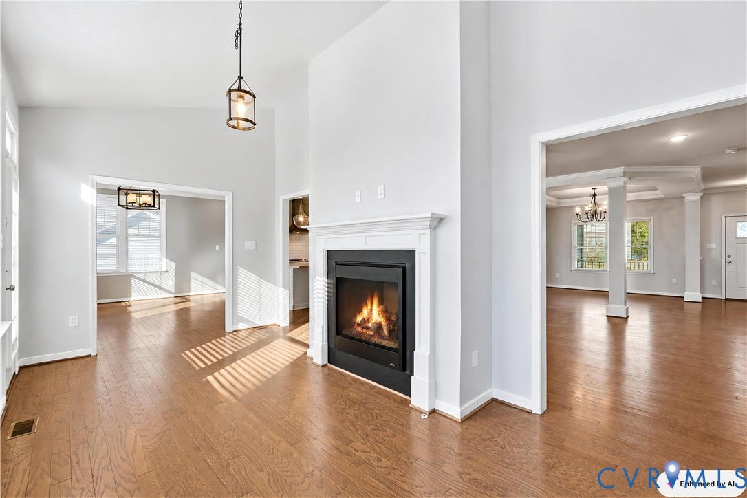 11936 Helmway Court, Chester, VA 23839 Fireplace with a classic white mantel surround, vaulted ceiling, wood-finish flooring, and pendant lighting