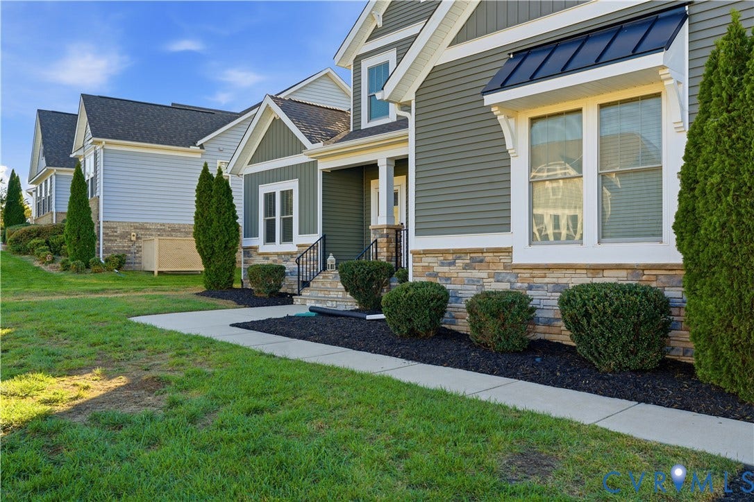 11936 Helmway Court, Chester, VA 23839 Exterior featuring horizontal lap siding, a stone veneer foundation, black metal roof awning, and multi-paned windows
