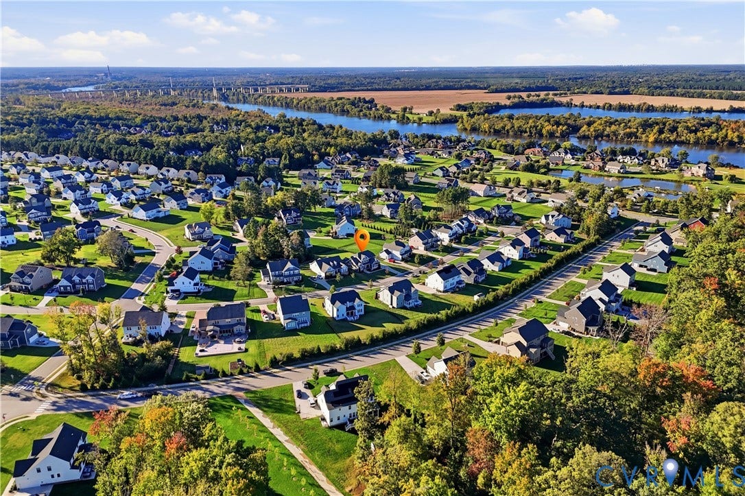 11936 Helmway Court, Chester, VA 23839 Aerial perspective of the residential community featuring paved streets, landscaped lots, and proximity to expansive waterfront and wooded areas